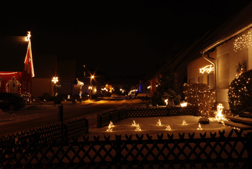 Die beleuchtete Schulstraße im Winter.