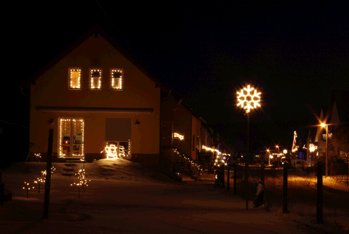 Die beleuchtete Schulstraße im Winter.